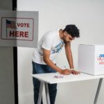 A young man at a polling station voting on election day, symbolizing democracy.