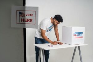 A young man at a polling station voting on election day, symbolizing democracy.