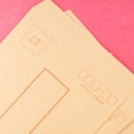 Close-up of traditional Asian envelopes on a vibrant pink background, perfect for stationery needs.