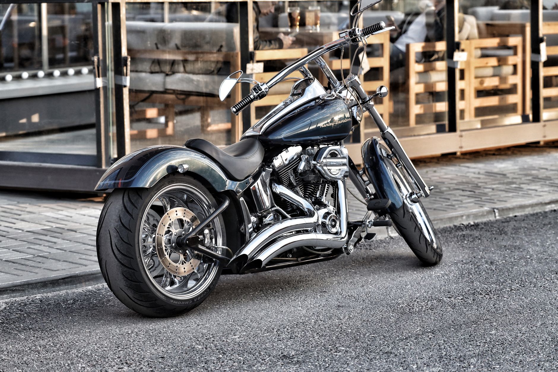 A sleek Harley-Davidson motorcycle parked on a city street, showcasing chrome detailing.
