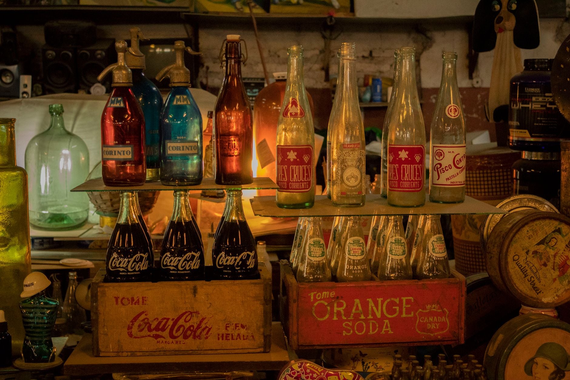 Assorted vintage soda bottles on display in a nostalgic, cozy setting.