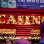 Illuminated casino sign glowing with bright lights during nighttime in a bustling city setting.