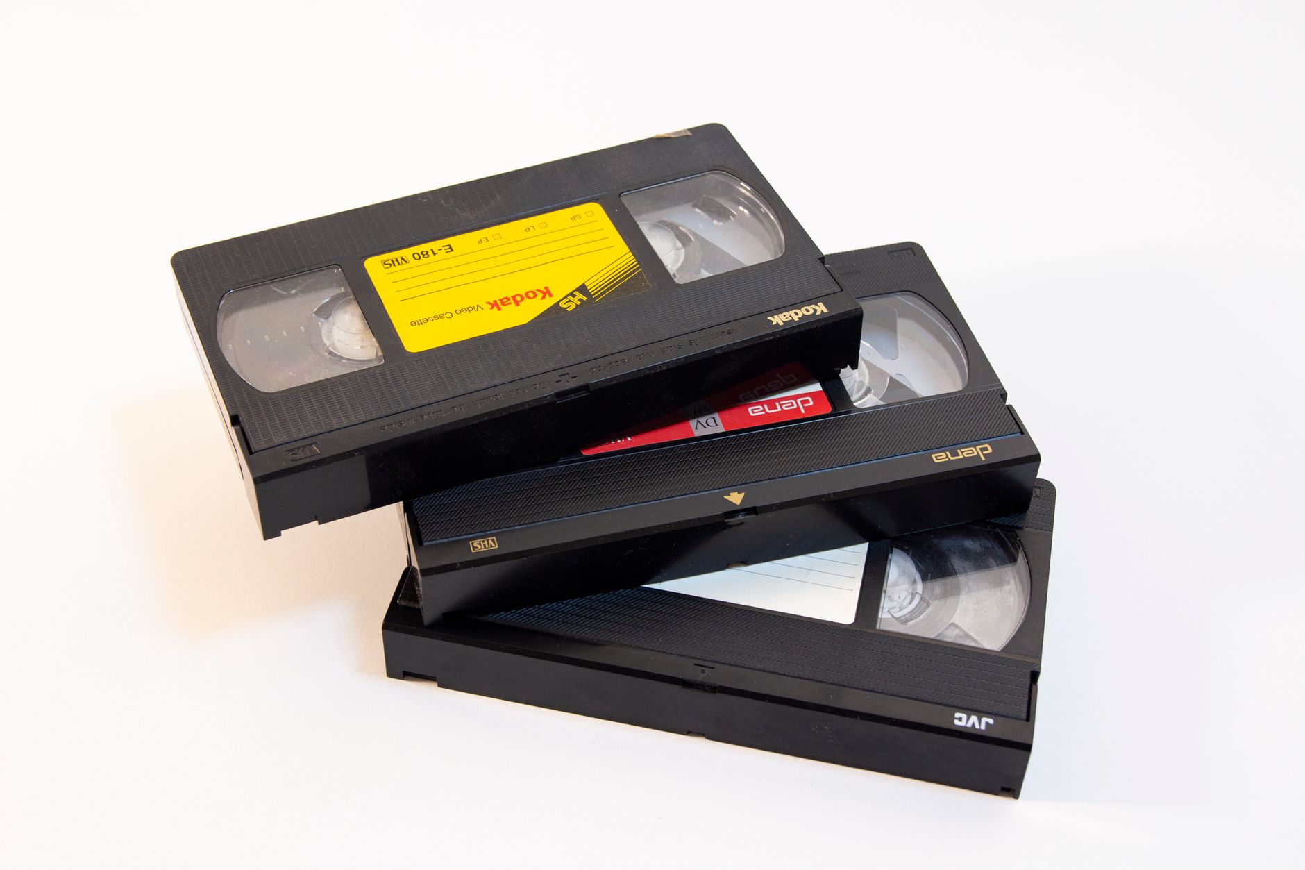 Three vintage VHS video cassette tapes stacked on a white background.