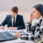 Two business professionals working together in an office, focusing on a project.