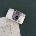 A classic Canon camera laying on a textured outdoor surface in Istanbul.